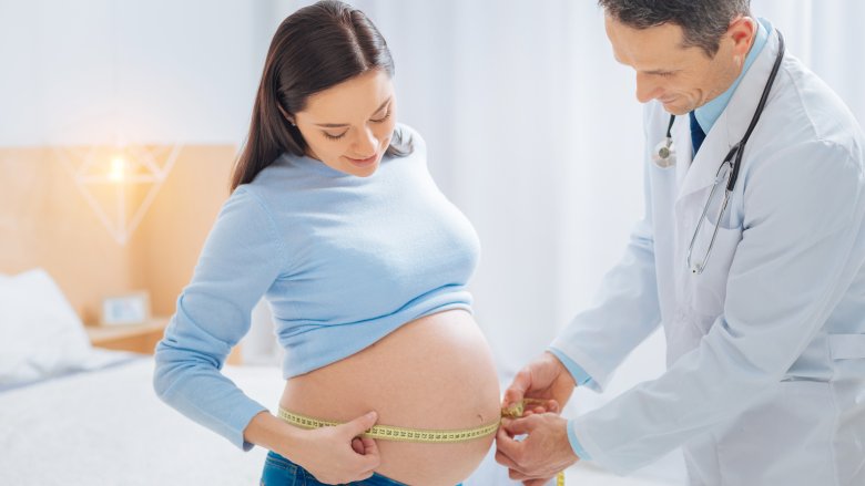 Doctor measuring pregnant woman's belly