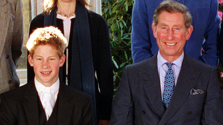 Young Prince Harry sitting next to King Charles