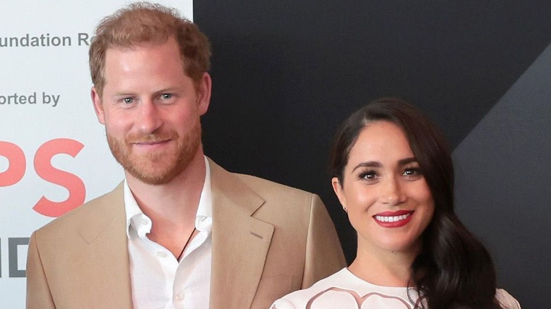 Prince Harry and Meghan Markle pose at an event