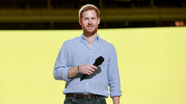 Prince Harry speaking at an event in light blue shirt