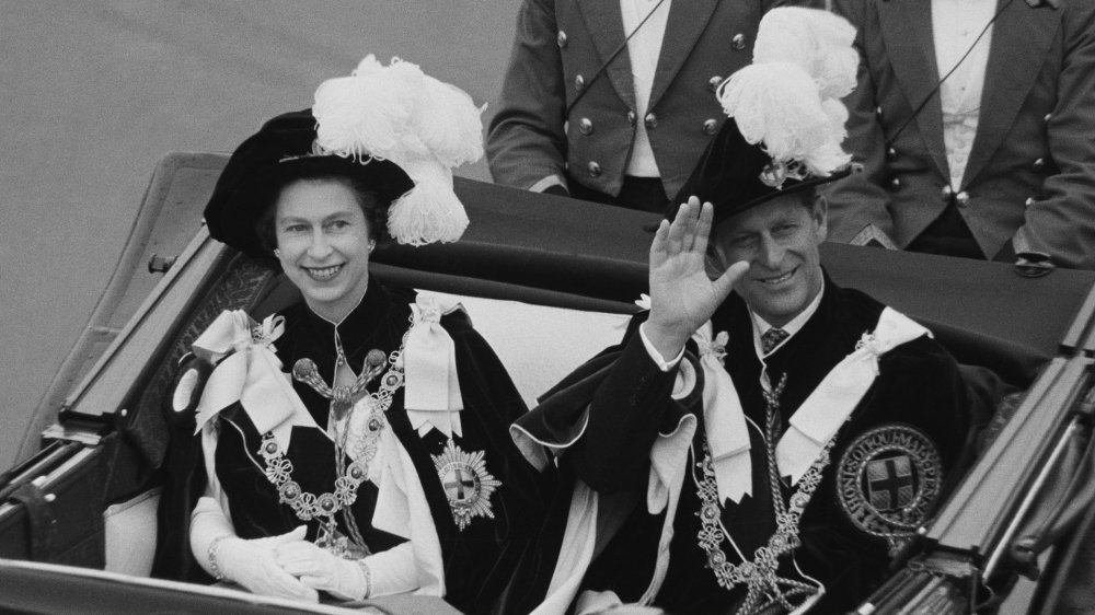 Queen Elizabeth and Prince Philip waving to the crowd in 1969