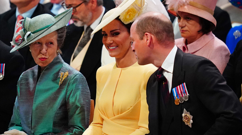 Princess Anne mischievously looking at Prince William