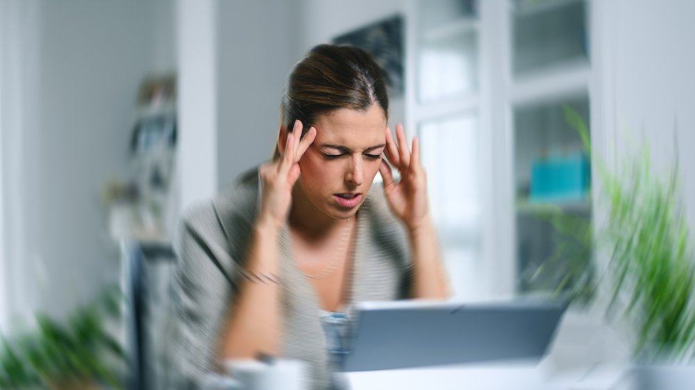 Woman with a headache in front of the computer