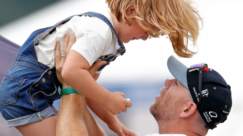 Mike Tindall carrying daughter