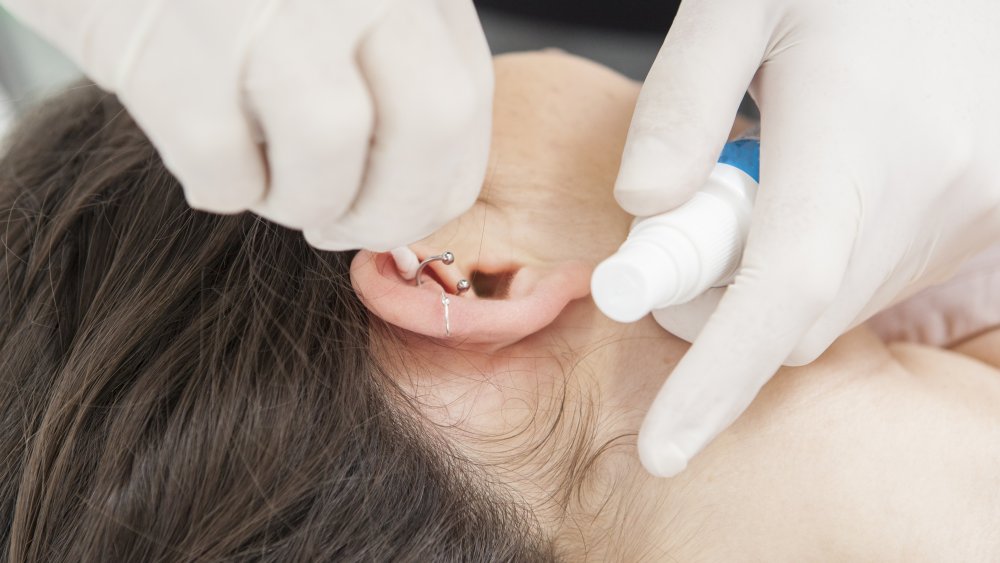 Woman getting her ear pierced 