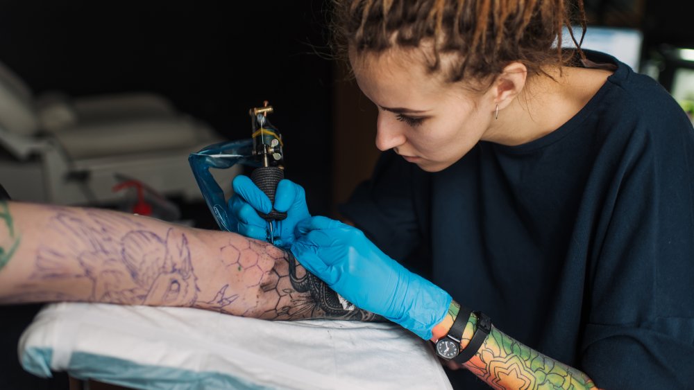 Tattoo artist working on a sleeve tattoo