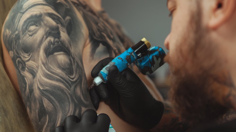 Tattoo artist working on a sleeve tattoo