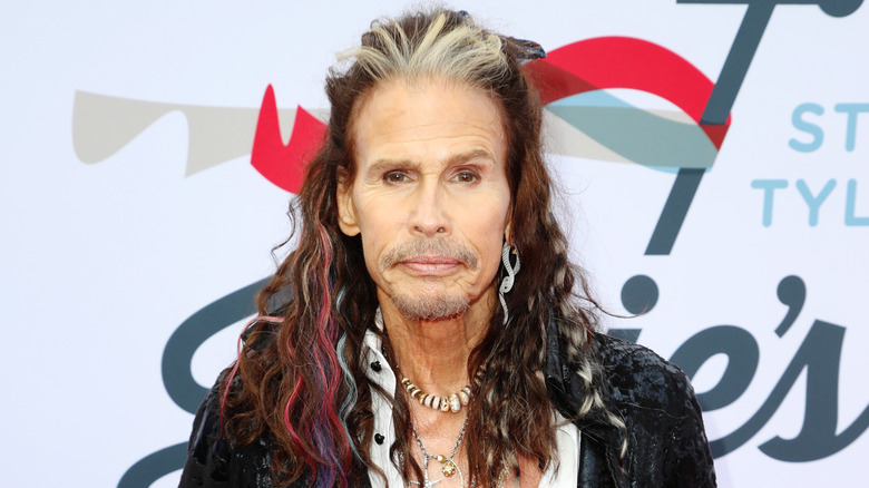 Steven Tyler poses for a photo at an event. 