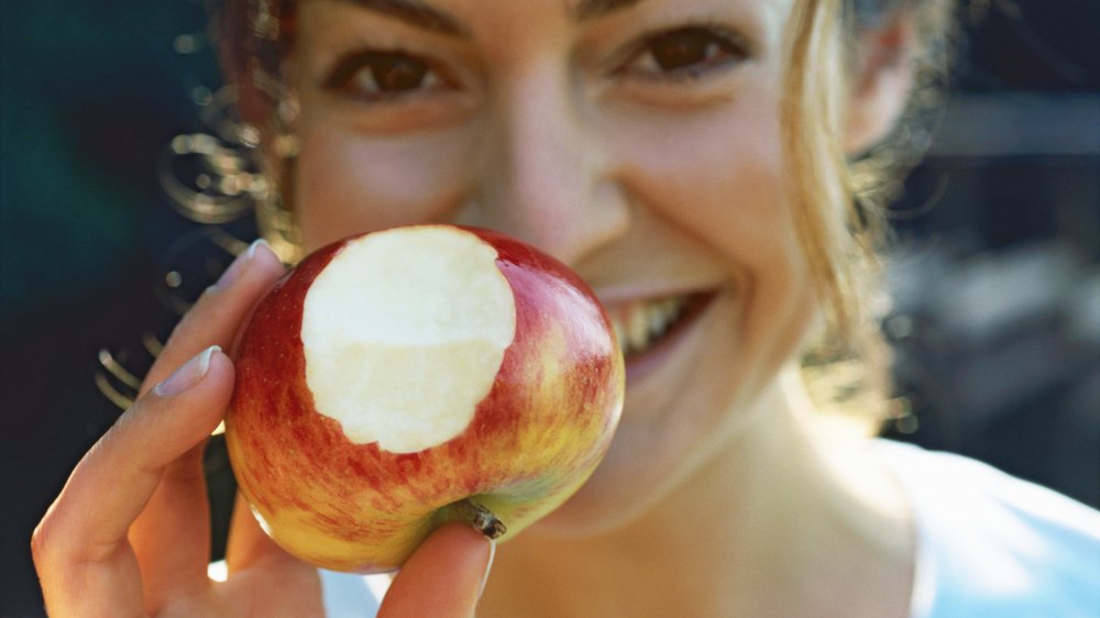 Happy, healthy woman with an apple