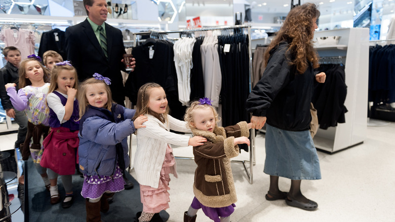 Michelle Duggar leading young daughters through clothing store