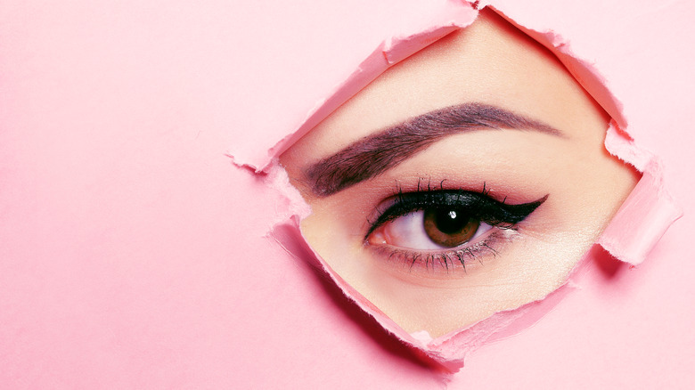 Woman's eye on a pink background