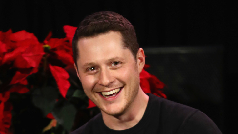 Noah Reid with roses behind him