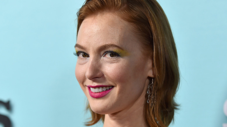 Alicia Witt headshot on blue background