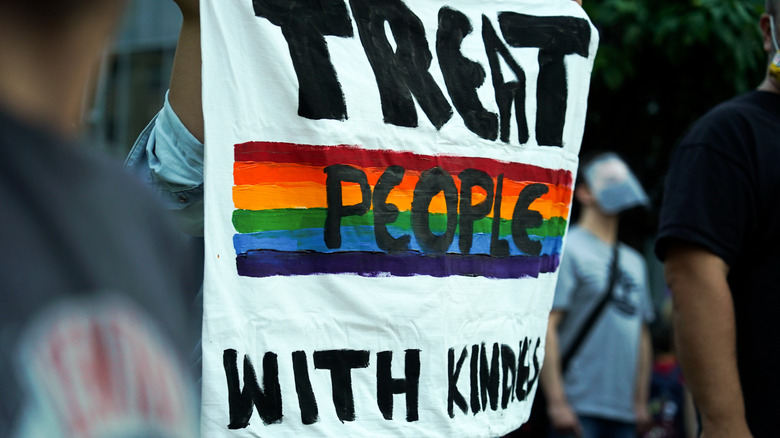 Protestors show a rainbow inspired sign