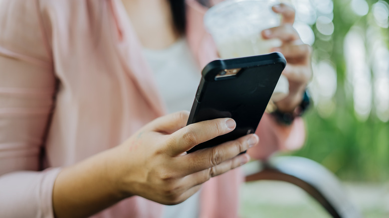 Close-up of a transgender woman's hands on her phone