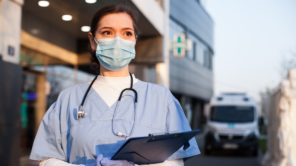 Doctor waits outside hospital in face mask