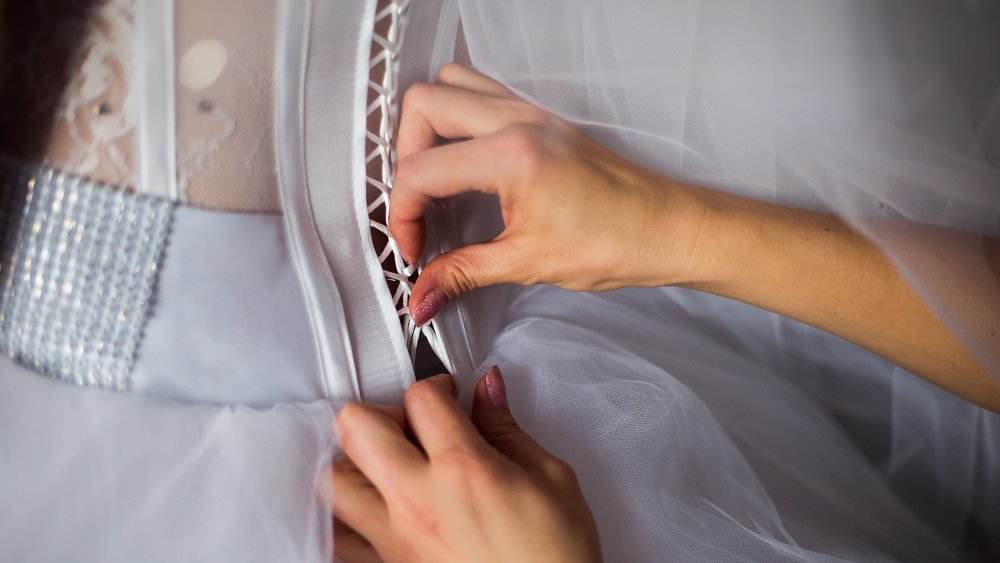 Bride's bustle being tied on