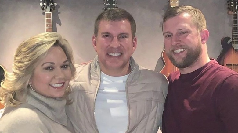 Kyle Chrisley smiles alongside Todd and Julie Chrisley