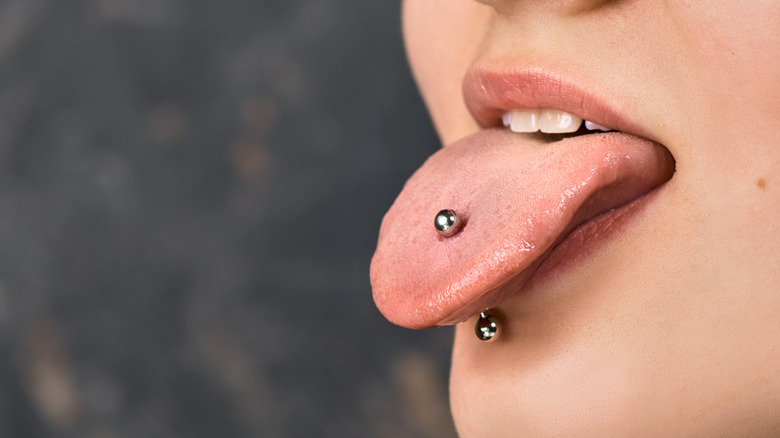 Tongue out with barbell piercing 