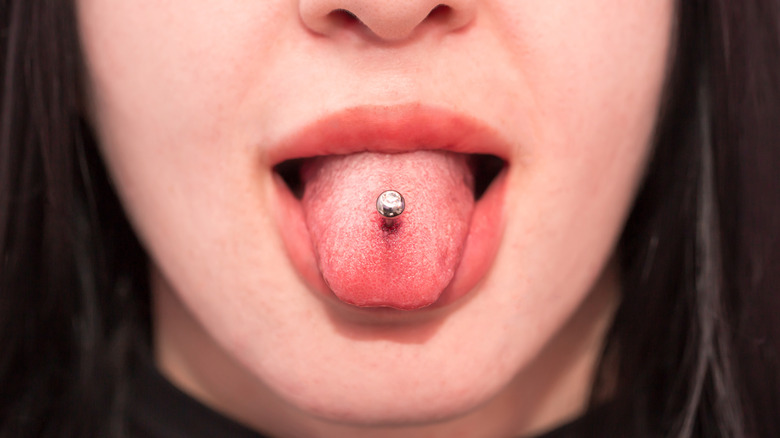 Metal tongue piercing with red lipstick