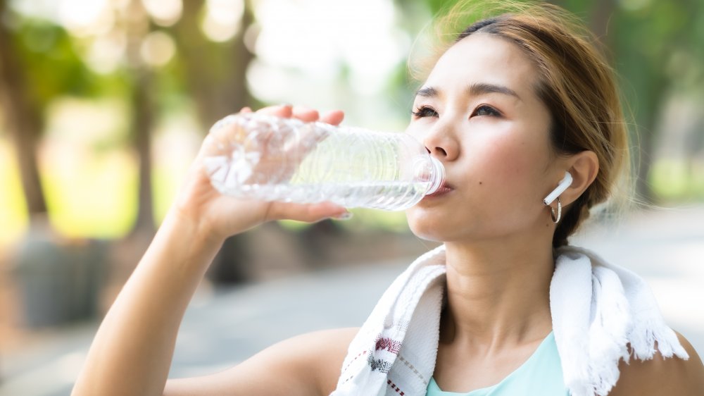 exercising woman drinking water