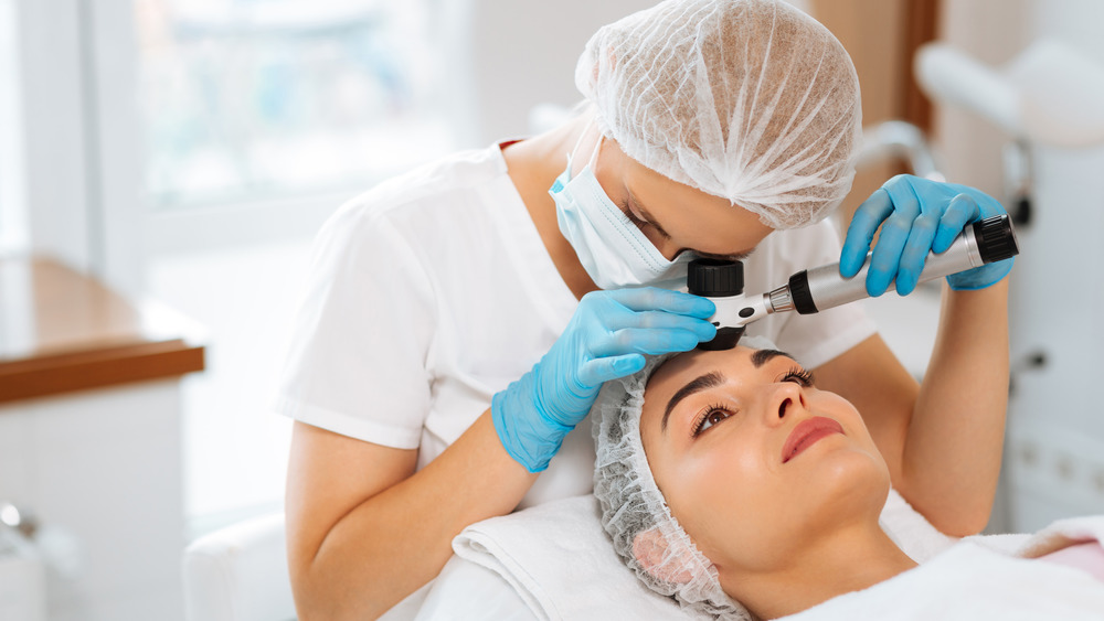 A dermatologist working on a patient