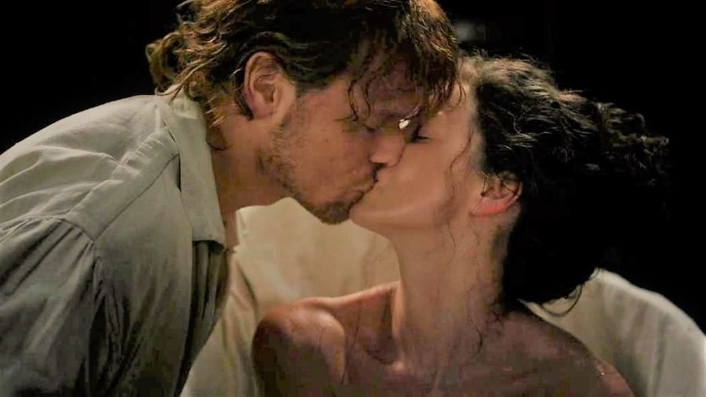 Jamie and Claire kissing in Outlander