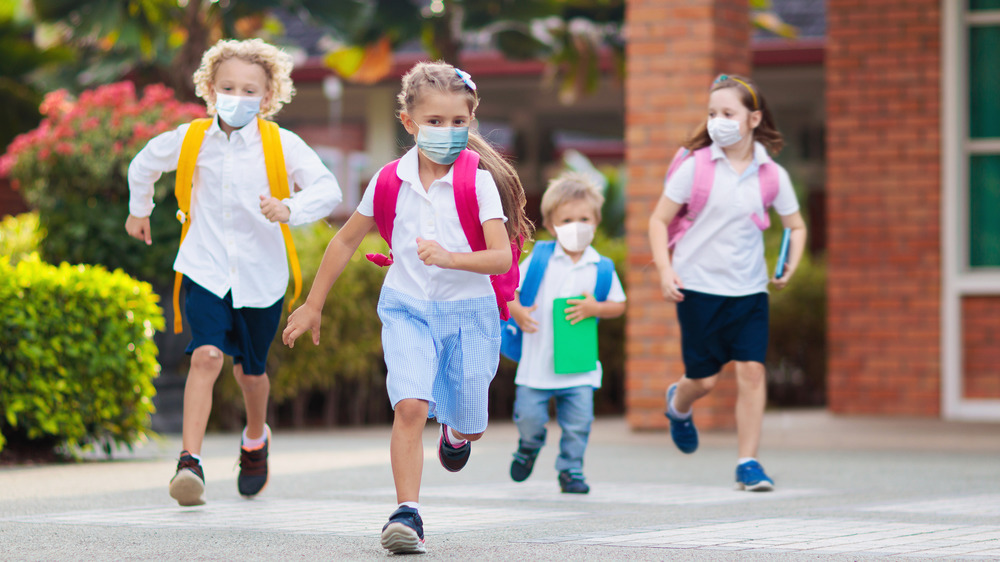 Children running outside while wearing masks 