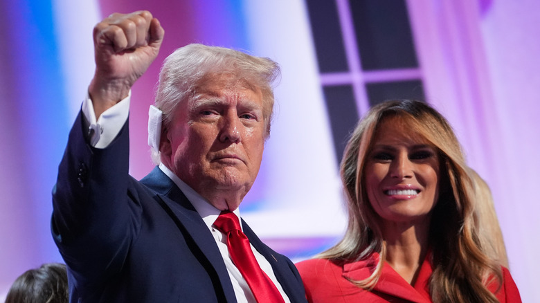 Donald Trump raising fist and Melania Trump smiling