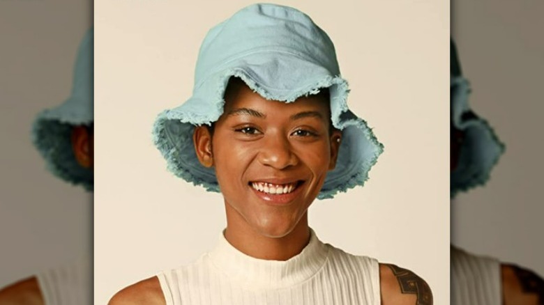 Black model wearing a blue bucket hat