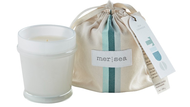 White candle with a striped canvas gift bag