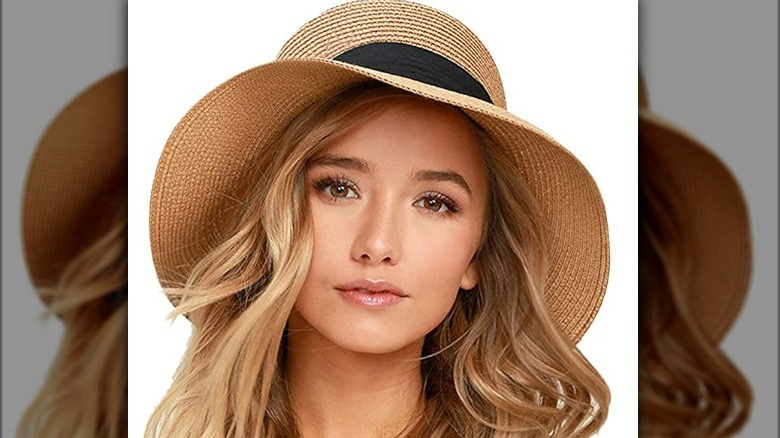 Model wearing straw hat with black accent