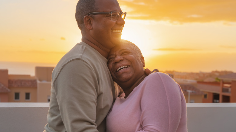 A man and woman embracing and smiling 