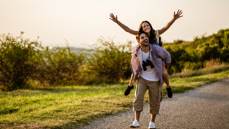 A woman on a man's shoulders in nature 