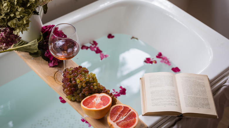 A bath with wine, snacks, and a book 