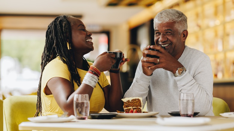 Older couple smiles while drinking coffee