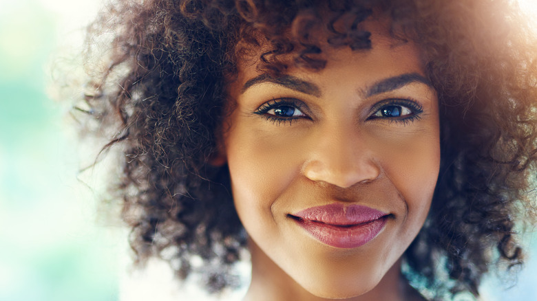 Young woman with curly hair smiling