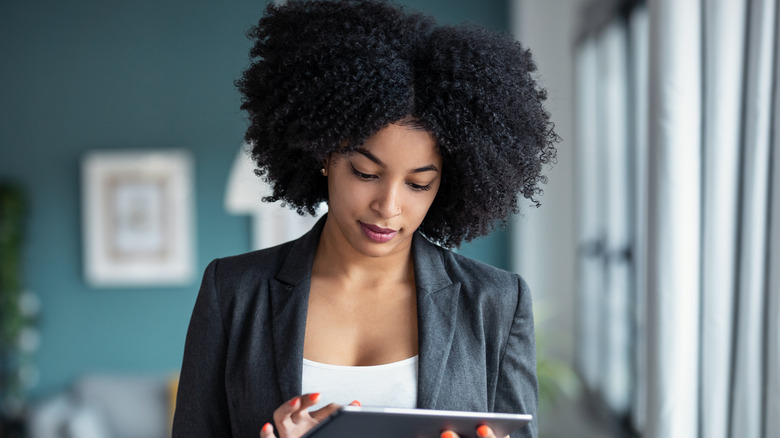 A woman with curly hair on a tablet