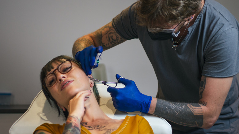 Woman getting a piercing