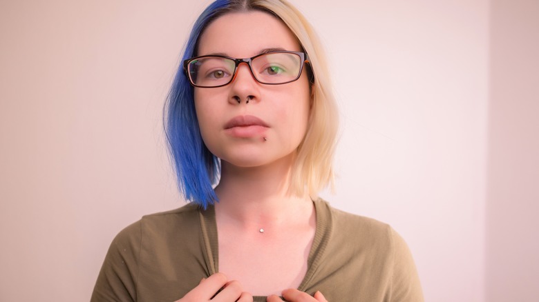 Woman showing neck dermal piercing
