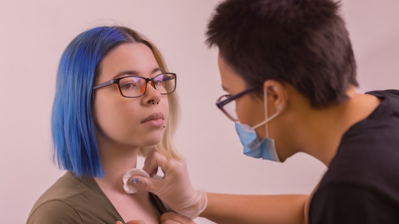 Woman getting prepped for a dermal piercing