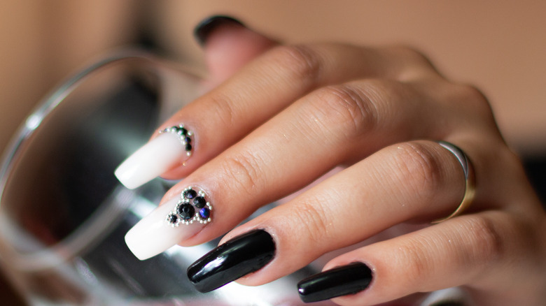 A hand with a VinyLux manicure, white and black nails