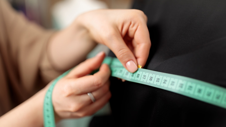 A hand using a measuring tape