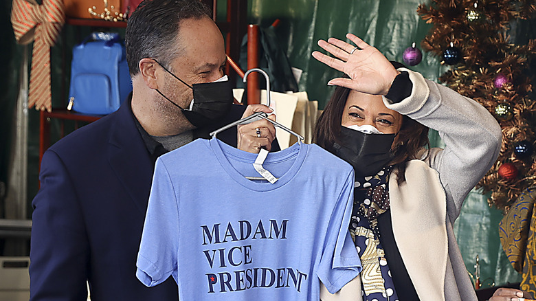 Doug Emhoff and Kamala Harris hold up a Madam VP shirt