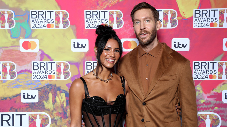 Vick Hope and Calvin Harris smiling together at the BRIT Awards 2024 