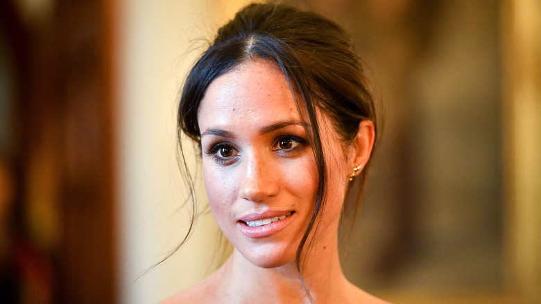 Meghan Markle smiling with her hair up