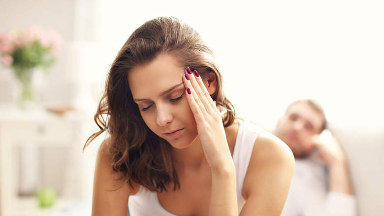 man in foreground woman upset