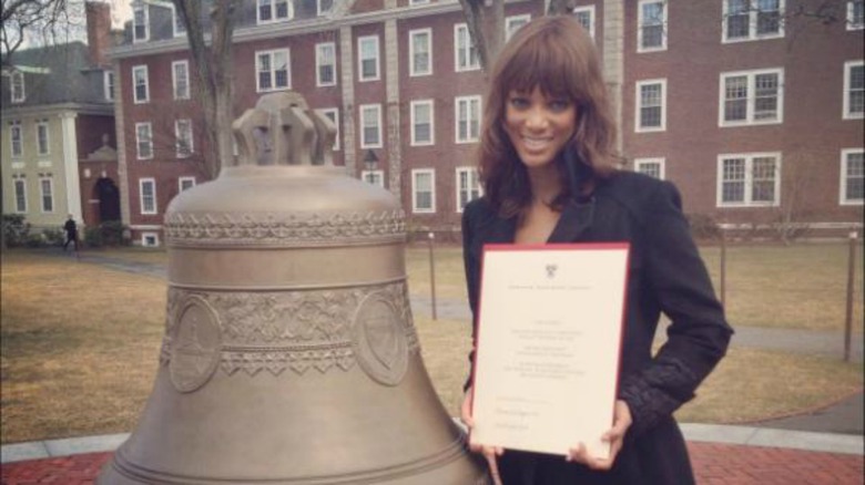 Tyra Banks holding a diploma