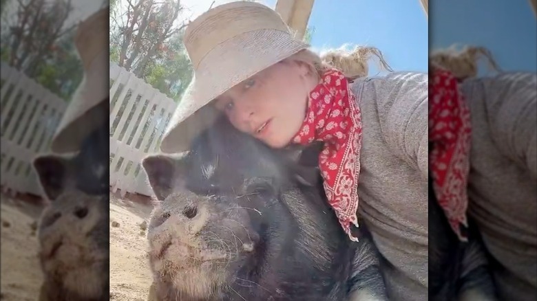 Beth Behrs cuddles up to a pig