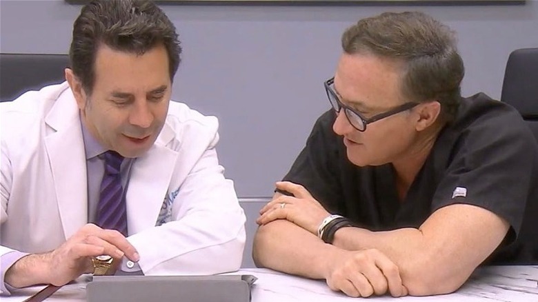 Drs. Paul Nassif and Terry Dubrow looking on tablet